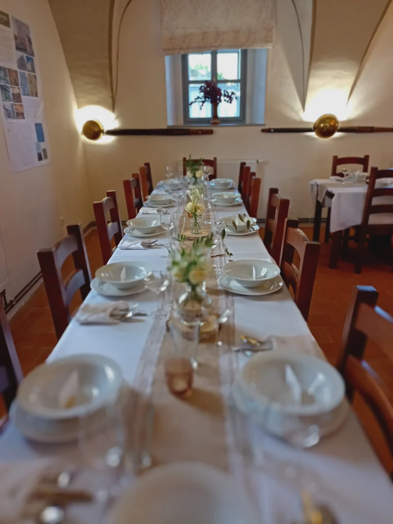 Prostřený jídelní stůl s květinovou dekorací.